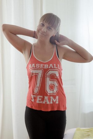 Young woman comes to massage and takes off baseball fan tank top lying down naked