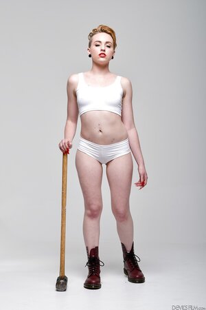 Pale-skinned bitch with short red hair and tongue piercing holds sledgehammer
