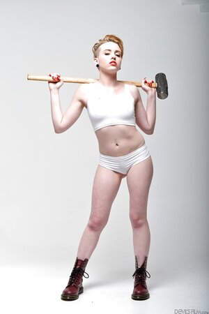 Pale-skinned bitch with short red hair and tongue piercing holds sledgehammer