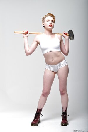 Pale-skinned bitch with short red hair and tongue piercing holds sledgehammer