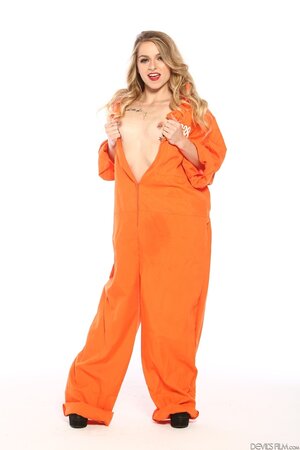 Female inmate in orange uniform flashes pierced nipple to seduce prison guard