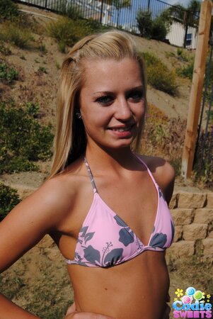 Sweet blonde slowly pulls sexy bikini down to demonstrate her slim body