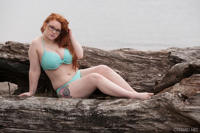 Plump ginger whore with glasses poses naked shaking her big tits outdoors