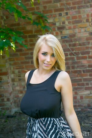 Blonde demonstrates her massive natural breasts and round ass outdoors