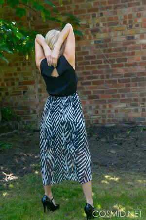 Blonde demonstrates her massive natural breasts and round ass outdoors