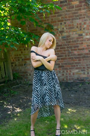 Blonde demonstrates her massive natural breasts and round ass outdoors