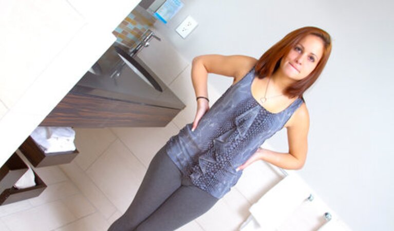 Red-haired cutie takes off yoga pants and poses with her tiny tits showing