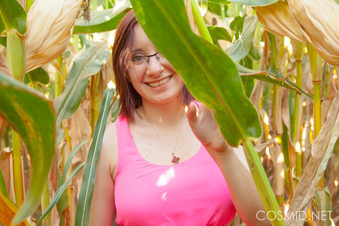 Slutty MILF with glasses takes off clothes to pose naked in the cornfield