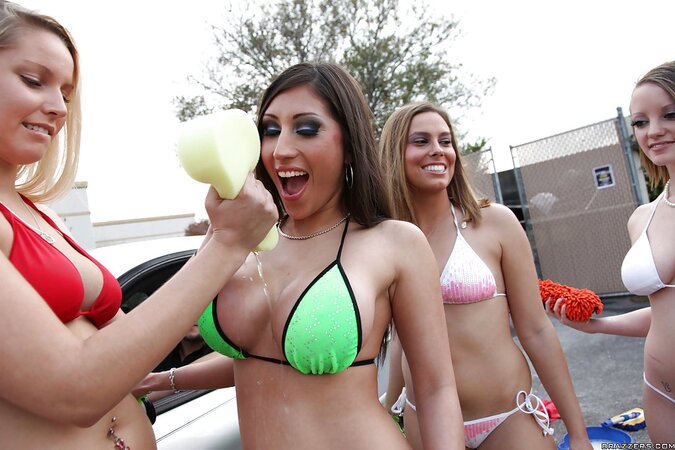 Four sexy girls wash the car and one of them exposes awesome big boobies