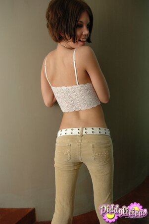 Girl unzips pants and pulls them down a little bit after turning around