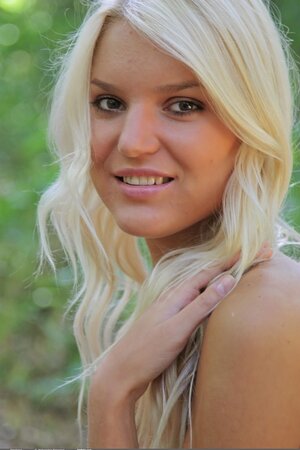 Blonde with tan lines demonstrates her wonderful naked body in the forest