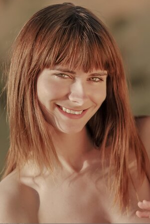 Red-haired girl with bangs prefers to chase butterflies wearing no clothes