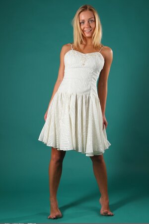 Blonde takes off white dress and shows her firm breasts in the studio