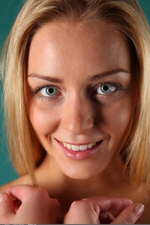 Blonde takes off white dress and shows her firm breasts in the studio