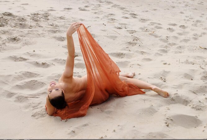 Playful brunette with sexy bush poses on the beach with only piece of cloth