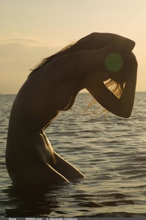 Svelte cutie with small tits and long legs poses absolutely naked on empty beach