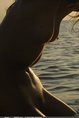 Svelte cutie with small tits and long legs poses absolutely naked on empty beach