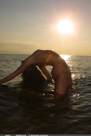 Svelte cutie with small tits and long legs poses absolutely naked on empty beach