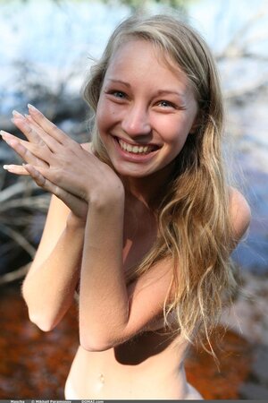 Adorable teen with sexy tan lines poses completely naked in watery marsh