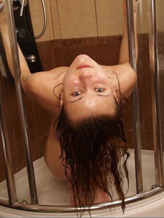 Naked and slender beauty seductively washes her amazing body in the shower