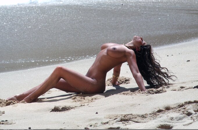 Stunning gal in sexy swimsuits demonstrates big hooters outdoors on the beach