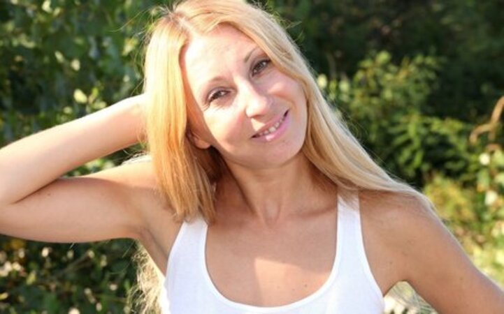Skinny Latina with blonde hair shows off her partially tanned body on the beach