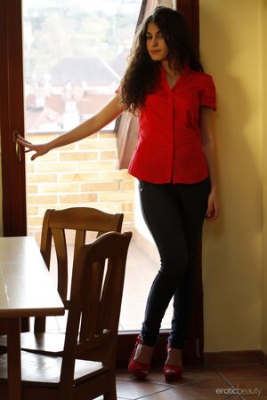 Long-haired solo brunette in jeans takes bra off to reveal her big natural tits