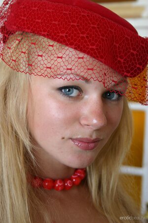 Chesty young blonde with a red hat on demonstrates her amazing curves