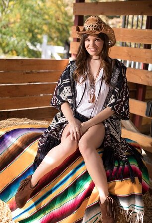 Cowgirl comes to the barn where she poses after stripping down to boots