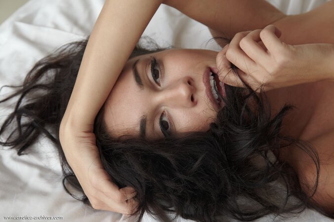 Young horny seductress wakes up in the morning and poses naked on the bed
