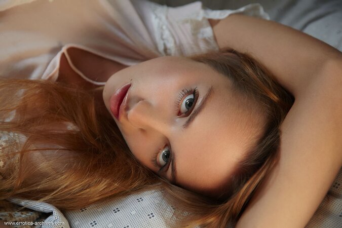Russian babe playfully gets naked and poses on the bed in her granny's house