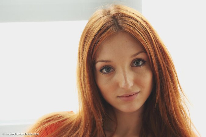 Red-haired nymph poses on the chair and shows all her natural assets