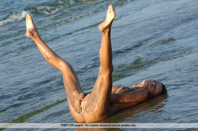Playful chick gets dirty and washes her completelly naked body in shallow water