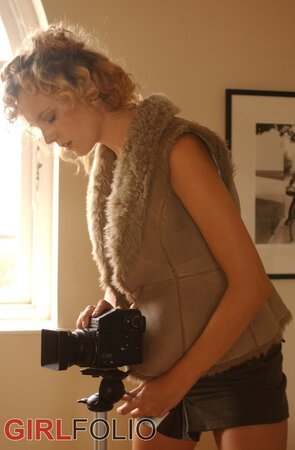 Blonde chick with curly hair takes erotic photos of herself while doffing clothes