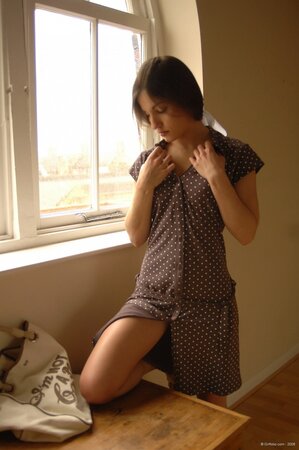 Skinny teen has no shame to strip and pose totally nude in front of the window