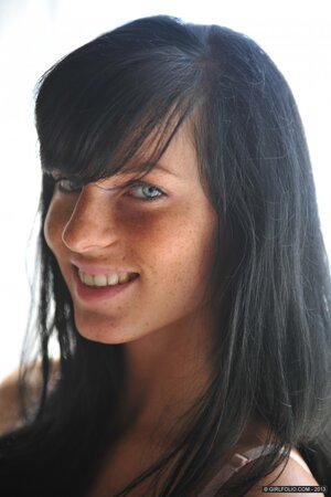Cute brunette girl drops off shirt to erotically pose in the bedroom
