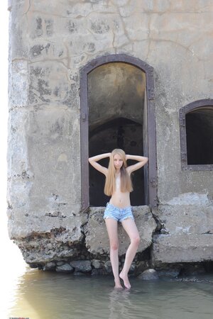 Pleasant Russian lassie reveals tits and pussy while posing naked by the water