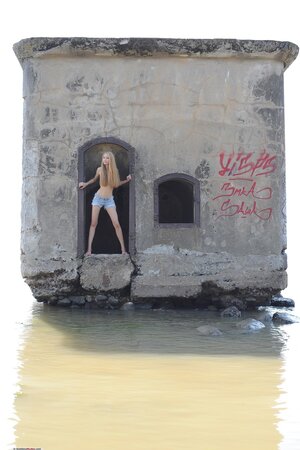 Pleasant Russian lassie reveals tits and pussy while posing naked by the water
