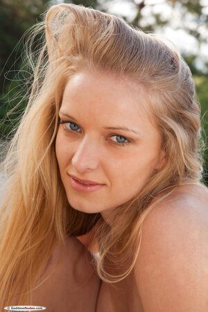 Charming blond lassie pulls off clothes to display her yummy naked body outdoors