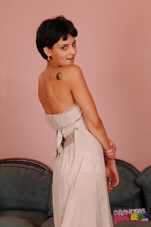 Flirty short-haired babe doffs long dress to tease with her young naked body