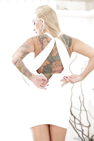 Inked blonde MILF with impressive tits gently touches own twat on daybed