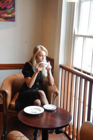 Nerdy-looking blonde gets naughty and hikes up her black dress to show panties