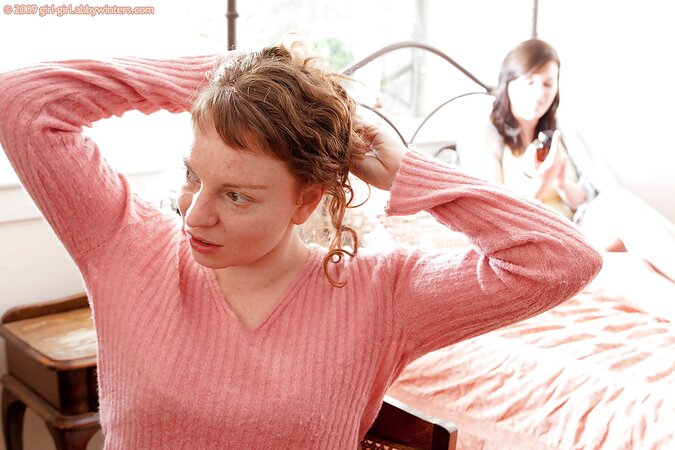 Redheaded girl arching her back during a hot lesbian sex sesh