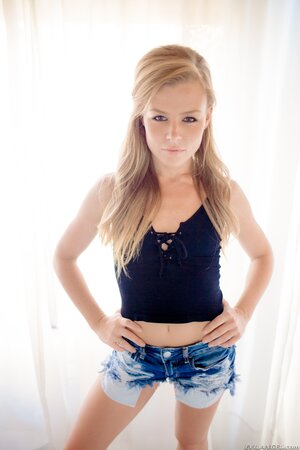 Petite sweetie poses in denim shorts then pulls them down to spread pussy