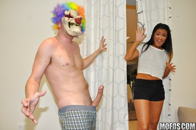 Prankster in scary clown mask stretches Asian girlfriend all over couch