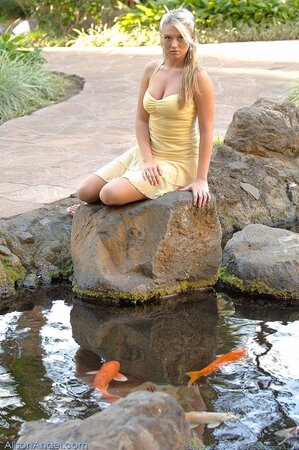 Young babe with blue eyes shows off herself while wearing a dress