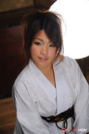 Cute young Japanese woman in a kimono participates in erotic photo session