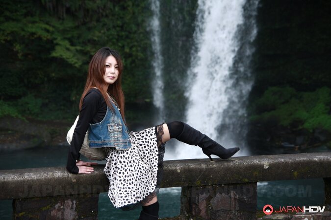Good-looking oriental lassie walks alone and slowly gets naked on camera