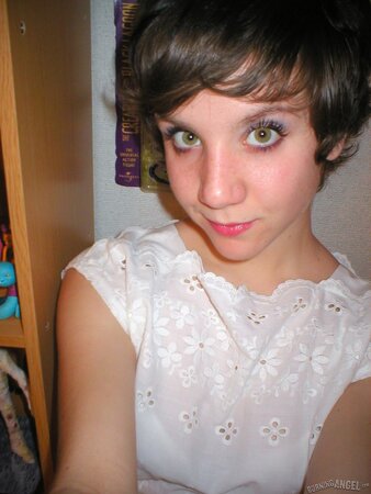 Schoolgirl with small boobs is posing for XXX pics in the bedroom