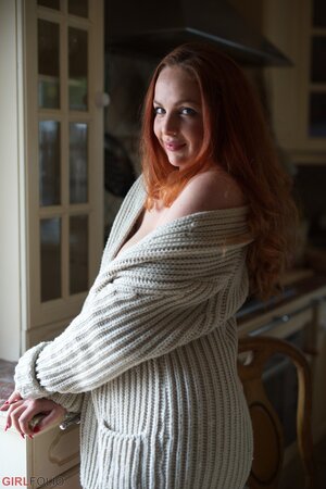 UK redhead Kara Carter enjoys rubbing cream into her big natural tits in the kitchen